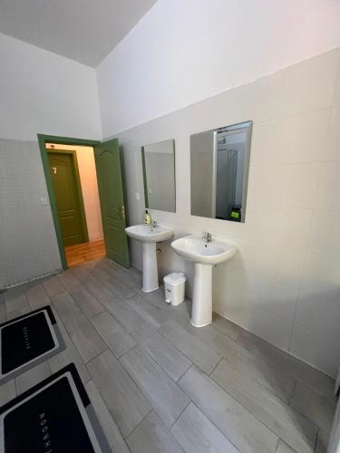a bathroom with two sinks and two mirrors at 7 Requinte HOSTel in Lisbon