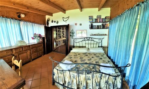 a bedroom with a bed in a room with blue curtains at VILLA CECILIA sul LAGO fronte MARE in Sperlonga