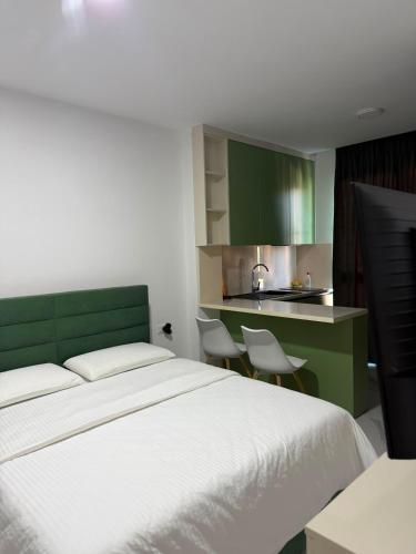 a bedroom with a large bed and a kitchen at Kurti Apartment in Golem
