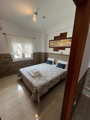 a bedroom with a bed and two windows at Sofia & Lakis House in Ormos Panagias