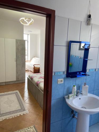 a bathroom with a sink and a mirror on the wall at Lushnja Apartament in Lushnjë