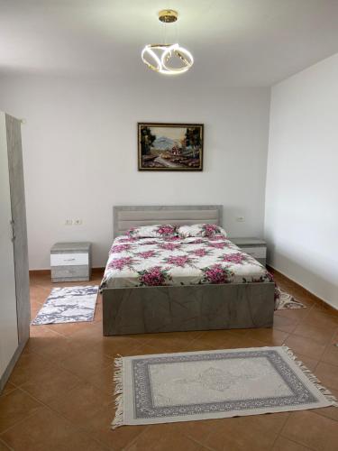 a bedroom with a bed in a white room at Lushnja Apartament in Lushnjë