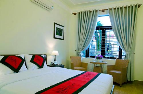 Un dormitorio con una cama grande y una ventana en An Hoi Town Homestay, en Hoi An