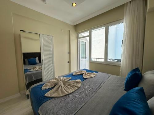a bedroom with a bed with two towels on it at Alas Garden City Apartment Fethiye in Fethiye