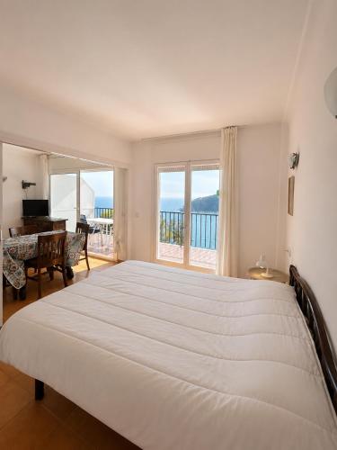 a bedroom with a large bed with a view of the ocean at Apartamentos Cala Llevado in Tossa de Mar