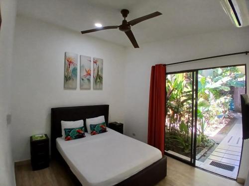a bedroom with a bed and a ceiling fan at Hotel Jaco Lodge in Jacó