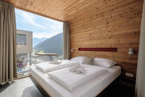 two beds in a room with a large window at Aradira in Kappl