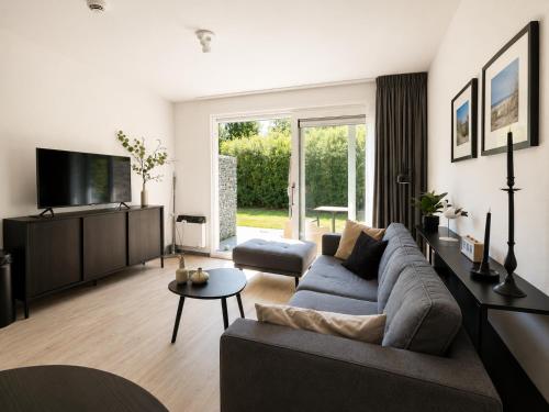 a living room with a couch and a tv at Prins Prachtig Amelander Kaap 97 in Hollum