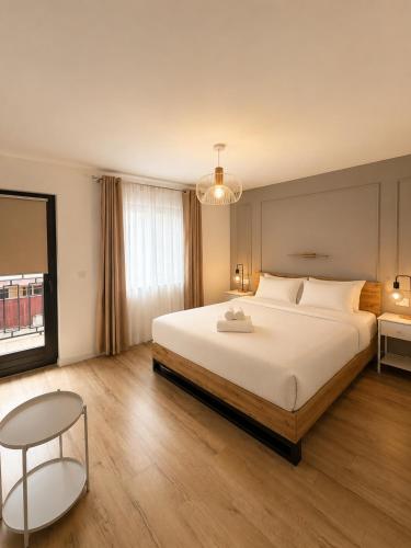 a bedroom with a large white bed and a table at Stai Ca Acasă in Slănic-Moldova