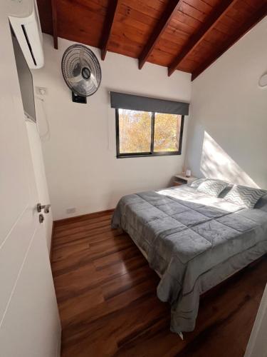 a bedroom with a bed and a window and a fan at FlussHaus VGB in Villa General Belgrano