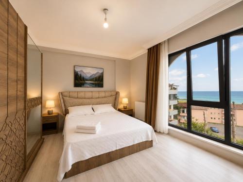 a bedroom with a bed and a large window at Pasha Residence in Trabzon
