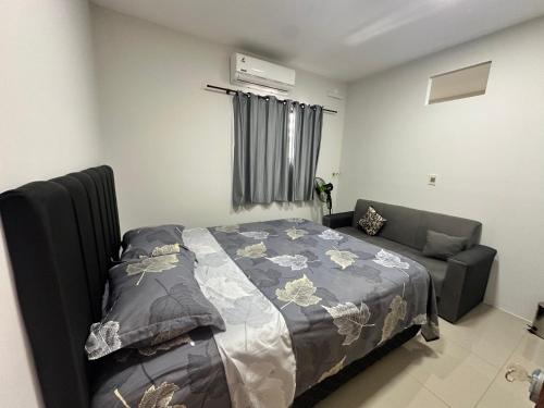 a bedroom with a bed and a couch at Casa independiente en Ciudad del Este in Ciudad del Este