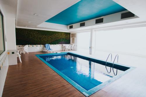 a swimming pool in a house with a blue ceiling at Sierra Huasteca Inn in Ciudad Valles