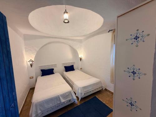 a small bedroom with two beds in a room at Houch Taguermess in Taguermess