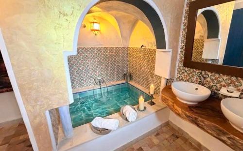 a bathroom with a tub and a sink at Houch Taguermess in Taguermess