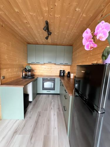 a small kitchen with wooden walls and wooden floors at Crow`s Nest Murmur Măguri in Măguri