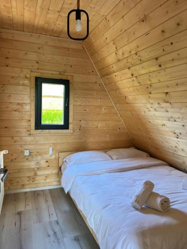 a bedroom with a bed in a wooden cabin at Crow`s Nest Murmur Măguri in Măguri