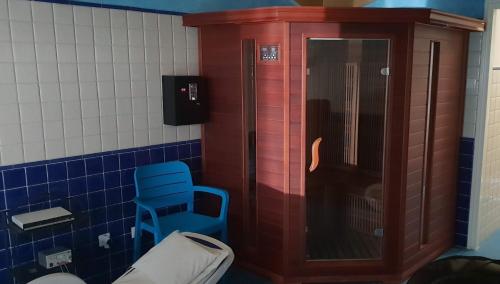 a bathroom with a wooden cabinet and a blue stool at Solar Club Apartman Sopron in Sopron