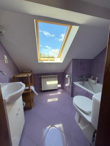 a bathroom with a window and a sink and a tub at Leśny Domek in Piłka