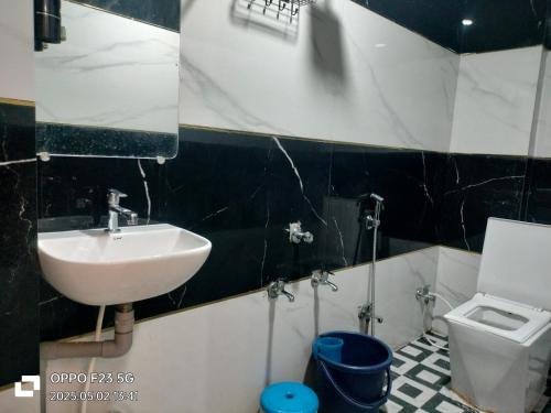 a bathroom with a sink and a toilet at Hotel Shree shivay omkareshwar in Godarpura
