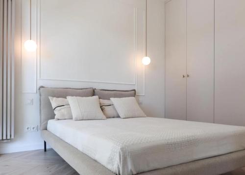 a white bedroom with a large bed with white walls at GW Apart in Gorzów Wielkopolski
