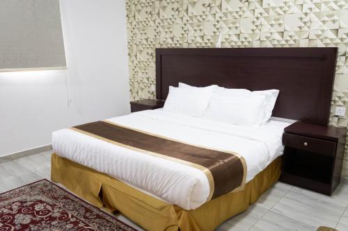 a bedroom with a large bed with a wooden headboard at مـهادا Mehada in Taif