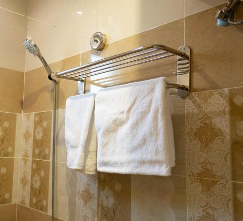 two white towels hanging on a towel rack in a bathroom at مـهادا Mehada in Taif