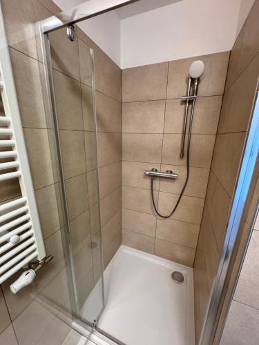 a bathroom with a shower with a glass door at Apartment Tatry Gerlachov, Vysoke Tatry in Svätý Jur