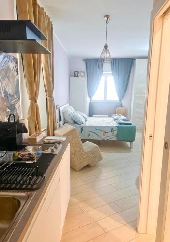 a kitchen with a room with a bed in the background at Casa Acquarello in Savona
