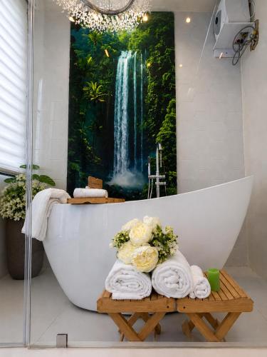 a bathroom with a waterfall painting on the wall at One Plus One Luxe Retreat with Airport Pickups in Sakumona