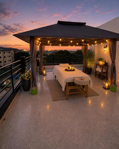 a gazebo with a table on a balcony with lights at One Plus One Luxe Retreat with Airport Pickups in Sakumona