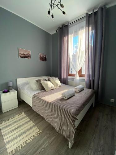 a bedroom with a large bed and a window at Loftson Apartament in Konin