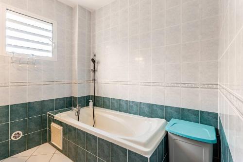 a bathroom with a tub and a toilet at Au Franciscea, climatiseurs, centre ville, sud in Saint-Louis