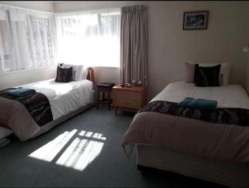 a hotel room with two beds and a window at Digs Homestay in Stratford