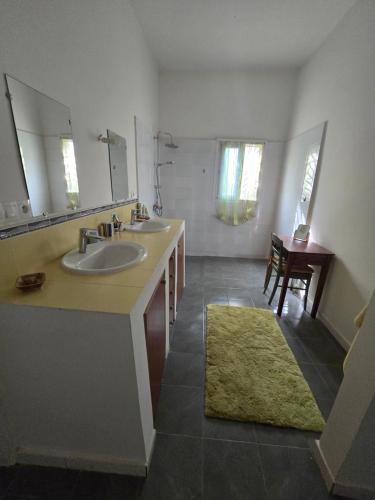 a bathroom with two sinks and a mirror at La Maison Ardiana in Oussouye