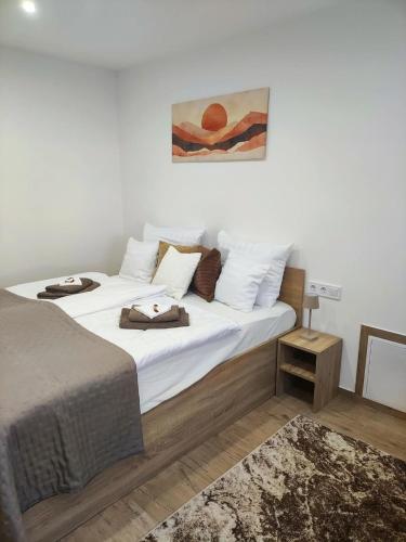 a bedroom with a large bed with white sheets and pillows at B30 Apartmanok, Eger in Eger
