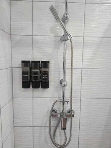 a shower in a bathroom with a shower head at B30 Apartmanok, Eger in Eger