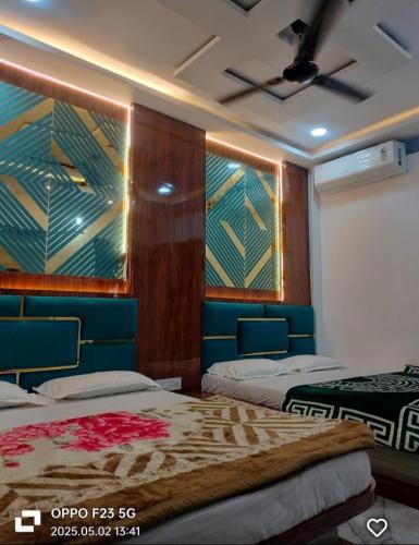 a bedroom with two beds and a ceiling fan at Hotel Shree shivay omkareshwar in Godarpura