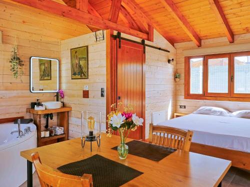 a bedroom with a bed and a table with a vase of flowers at Luxury Rural Cuenca - Villas in Cuenca