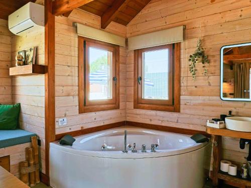 a large tub in a wooden room with two windows at Luxury Rural Cuenca - Villas in Cuenca