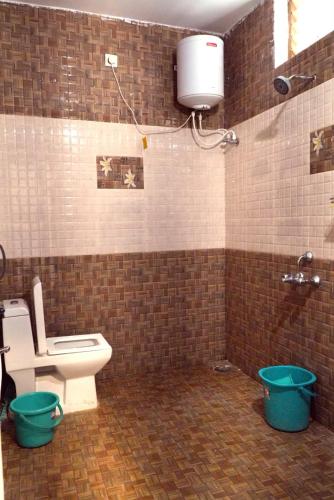 a bathroom with a toilet and a water tank at Arupa Homestay in Ooty