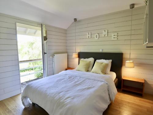 a bedroom with a bed with white sheets and a window at Le Moulin de Rendeux in Rendeux