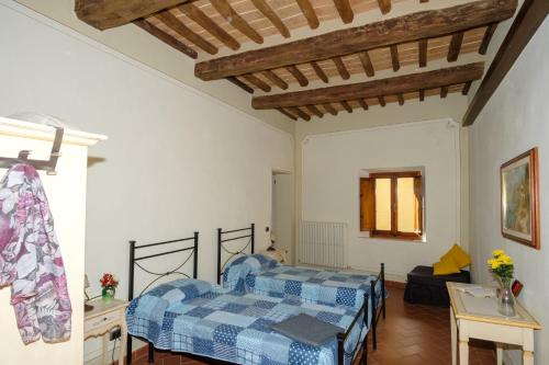 a bedroom with two beds and a table at Relais Villa Sensano in Pignano