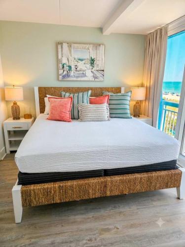 a bedroom with a large bed with colorful pillows at Lavish Coastal Oceanfront Suite Yachtsman 401 in Myrtle Beach