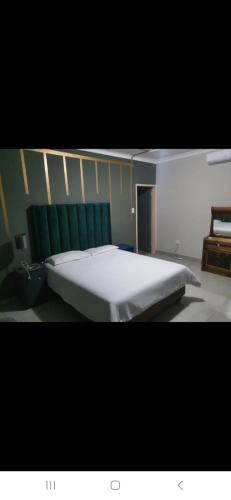 a large bed in a room with a green wall at Cooperville 1 in Potchefstroom