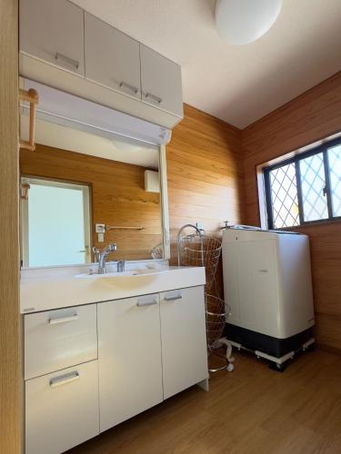 a kitchen with white cabinets and a sink and a window at Hourokusha - Vacation STAY 13417 in Doji