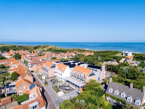 an aerial view of a small town with houses and the ocean at Hotel The Dunes in Domburg