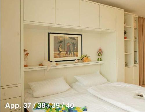 a bedroom with two white beds and a painting at Forum Marinar 38 in Bansin