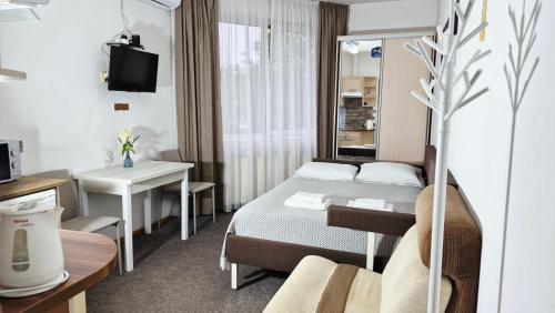 a small hotel room with a bed and a table at АВІА in Uzhhorod