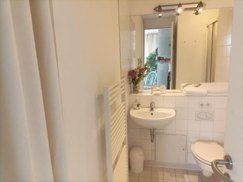 a bathroom with a sink and a toilet and a mirror at Forum Marinar 37 in Bansin